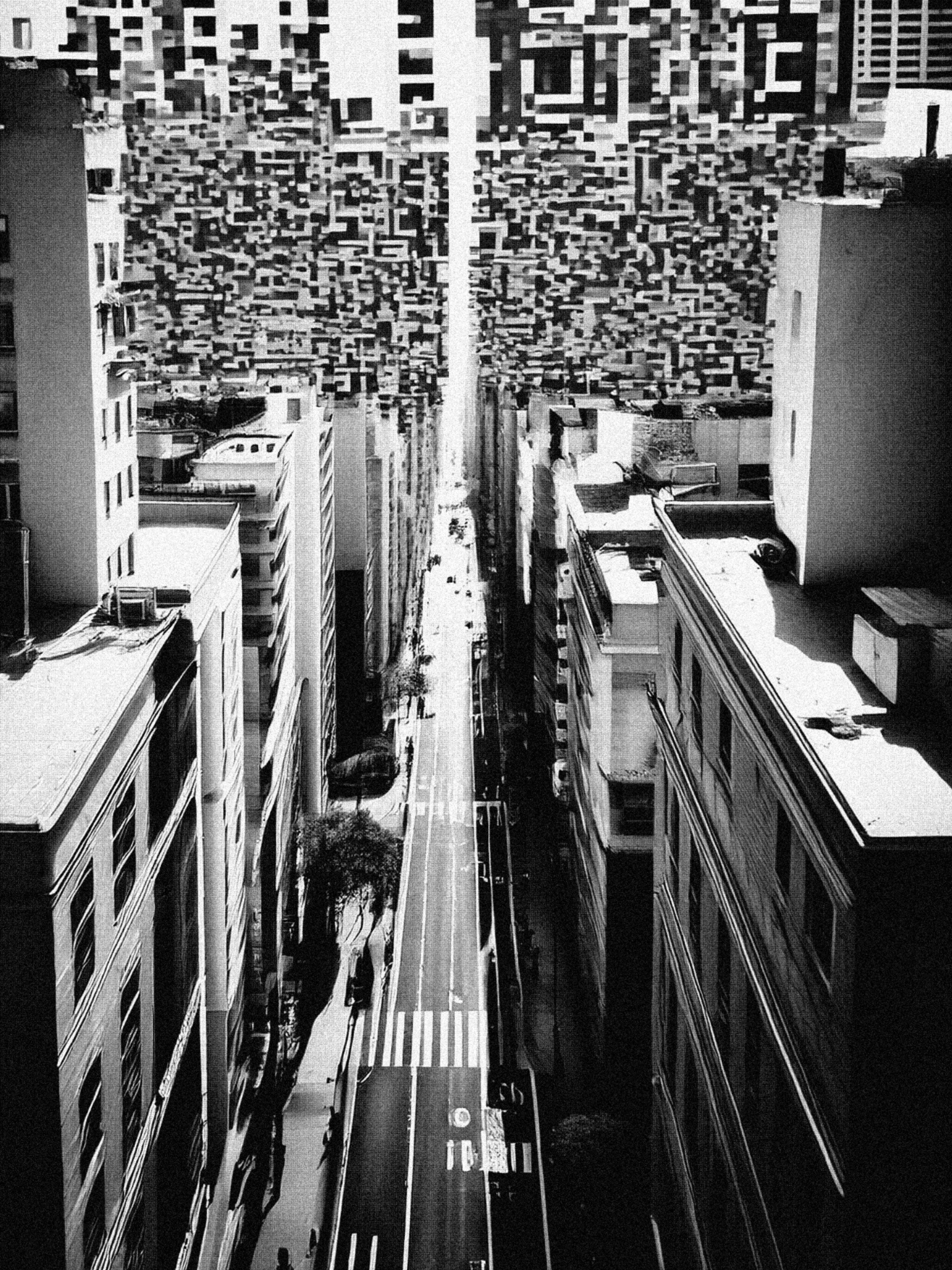 The black and white image shows a high shot of the tops of a city scene. At eye level are the tops of the tall buildings on either side of the street, in the middle of the image, it tunnels down to the road below. The street is fairly empty, but cascading down from the sky are pixels which look like a QR code pattern – almost like these represent the clouds. 